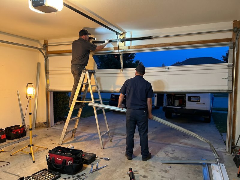 Technicians with a ladder at a raised garage door