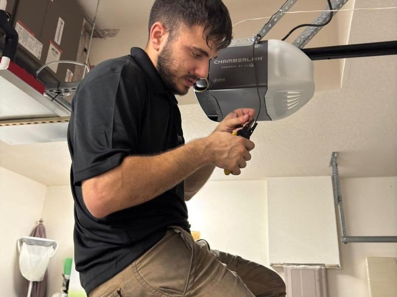 Technician working at an overhead garage door opener