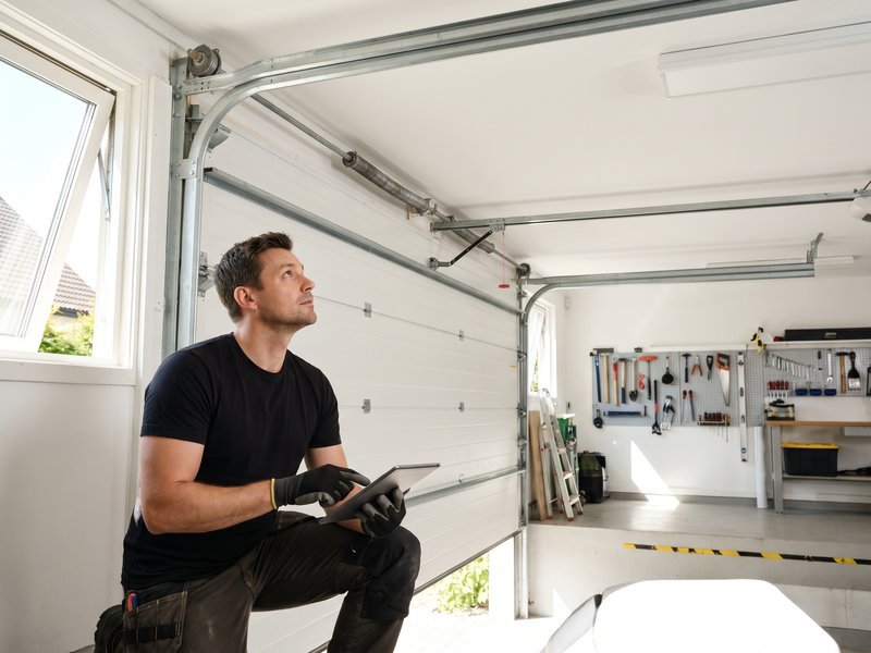 Technician inspecting an opener near the door header