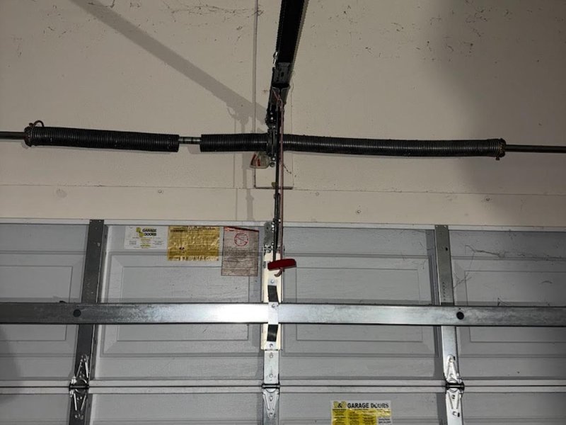 Torsion spring and center bracket above a sectional door